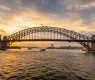sydney-harbor-bridge-at-sunset-and-a-boat-sailing