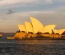 sydney-opera-house-at-sunset-boat-sailing-by-it-new